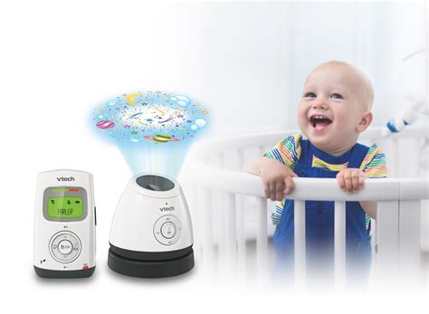 Vaikas miega lovelėje, šalia Vtech mobili auklė