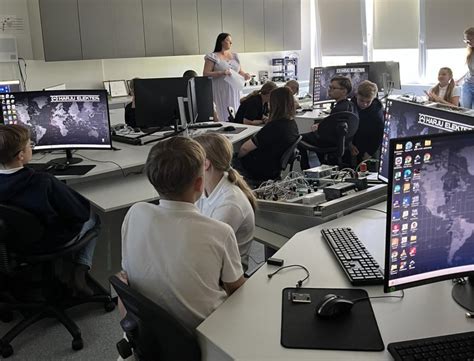 Mokiniai dirbantys STEAM centre su kompiuteriais