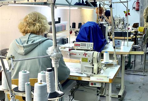 Moteris prie siuvimo mašinos siuvanti kaukes karantino metu