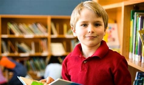 Vaikas su rusiška knyga ir atvertu planšetiniu kompiuteriu