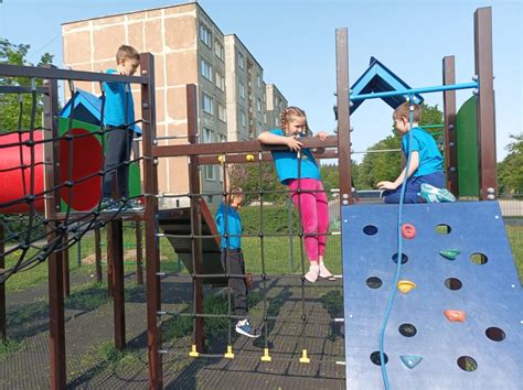 Vaikai žaidimų aikštelėje prie spalvingos čiuožyklos