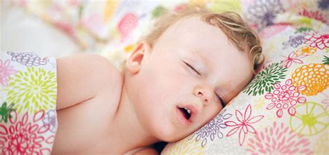 kūdikis saldžiai miega saugioje lovytėje su tinkamu čiužiniu