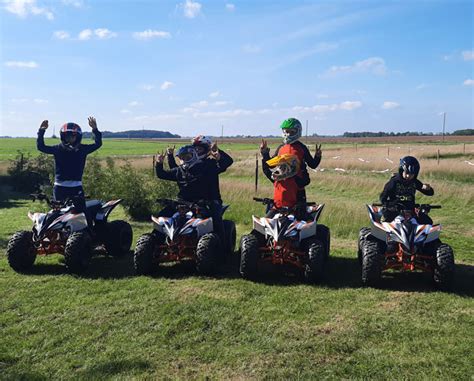 vaikų grupė važiuoja elektriniais keturračiais