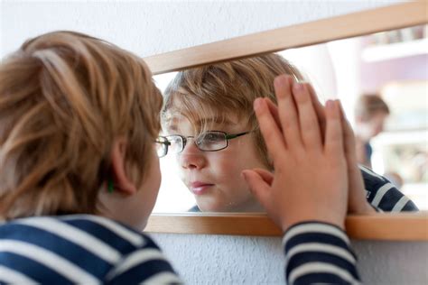 Vaikas matuojasi golfą prie veidrodžio