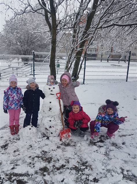 Vaikai žaidžia sniege, lipdo sniego senį