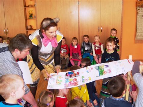 Draugiškai nusiteikę vaikai prie stalo su molio dirbiniais ir kūrybinėmis priemonėmis