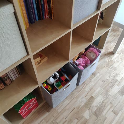 Tvarkingas vaiko kambarys su spalvingomis kartoninėmis dėžėmis žaislams laikyti