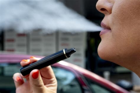 Jauni žmonės su elektroninėmis cigaretėmis