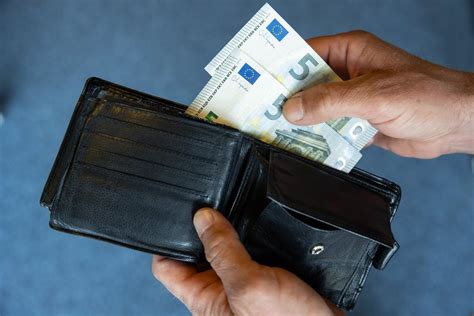 Rankos, laikančios pinigų banknotus, simbolizuojančios finansinę paramą globėjams