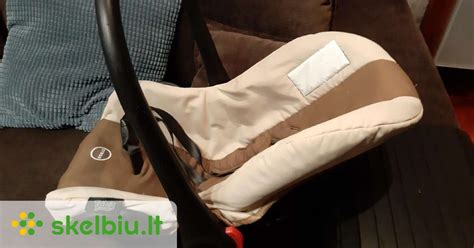 Tėvai su naujagimiu ir automobilio kėdute