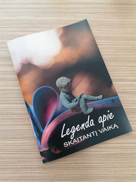 vaikas skaitantis knygą apie gamtą miške