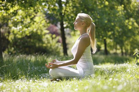 Simbolinis vaizdas: moteris medituoja gamtoje