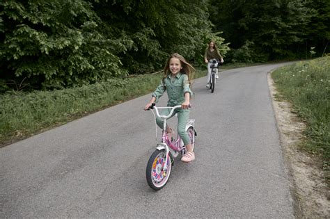 Vaikas važiuojantis jam per dideliu dviračiu