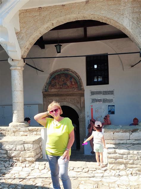 Du tėvai, laikantys už rankų savo vaiką, kuris žiūri į juos su šypsena. Vaikas atrodo laimingas, o tėvai jį palaiko.