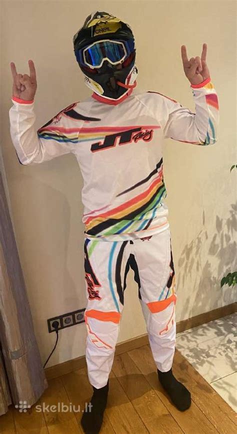 Vaikas su motokroso apranga ant elektrinio motociklo
