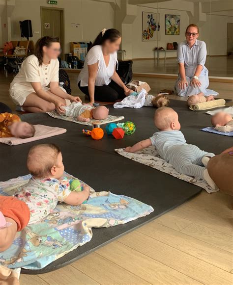 Grupė mamų su kūdikiais atlieka pratimus