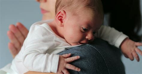 Tėvai su kūdikiu ant rankų, užtikrinantys artumą ir saugumą