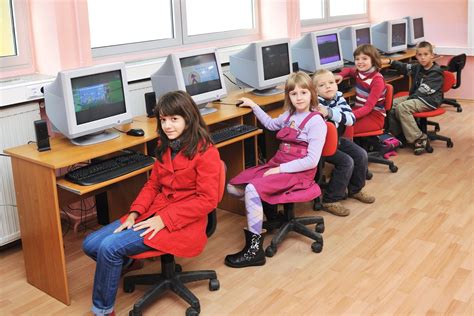 vaikai sėdi prie kompiuterių mokydamiesi