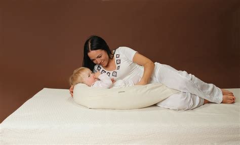 mama žindo kūdikį patogioje padėtyje su pagalve