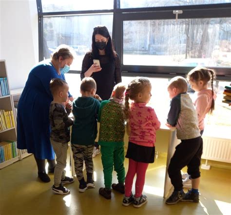Linksmi personažai pasitinka vaikus darželio kieme