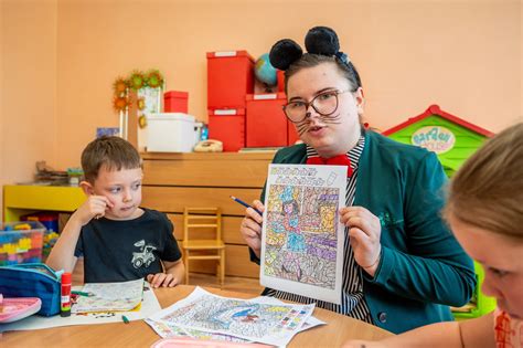 Auklėtoja bendrauja su vaikais, stebėdama jų poreikius
