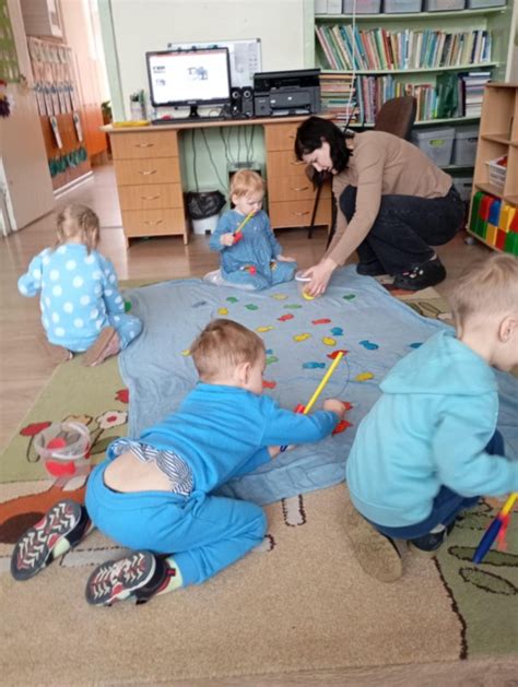Vaikai, piešiantys ir užsiimantys kūrybine veikla darželyje