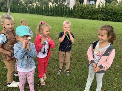 Vaikų grupė, besišypsanti darželio kieme