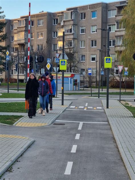 Mokiniai su gėlėmis einantys į mokyklą