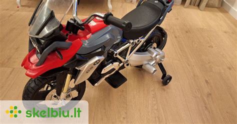 Suaugęs asmuo valo vaikišką motociklą