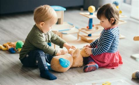 Vaikai žaidžia darželyje ir dalinasi žaislais