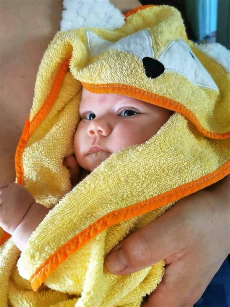 kūdikis susuptas į švelnų rankšluostį po maudynių