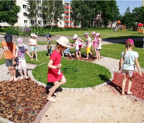 Vaikai, žaidžiantys gerai įrengtoje darželio aikštelėje