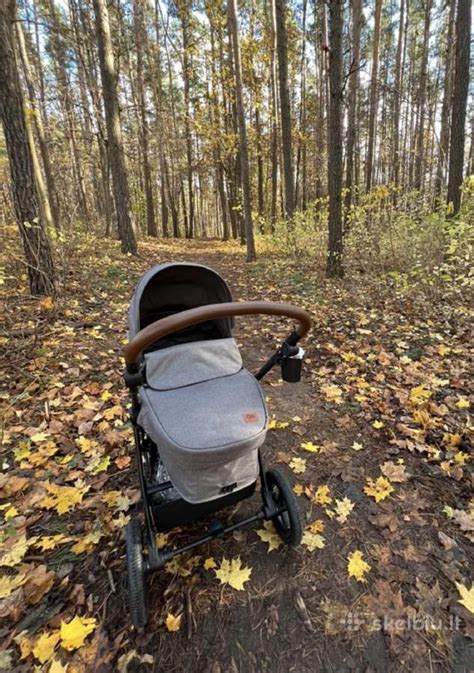 Tėvai su sportiniu vežimėliu pasivaikščiojime gamtoje