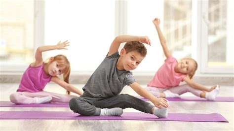 Vaikai atlieka pratimus ant gimnastikos kilimėlių
