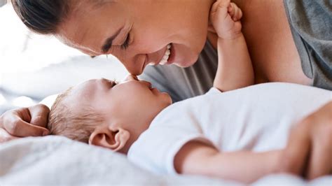 Mama su kūdikiu maitinimo pagalvėje