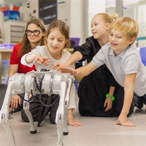 Vaikų grupė supažindinama su robotikos įranga ir demonstruoja sukurtus robotus