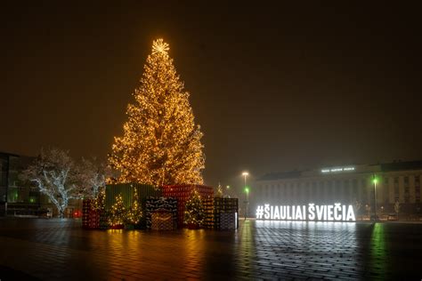 Šeima puošianti kalėdinę eglutę