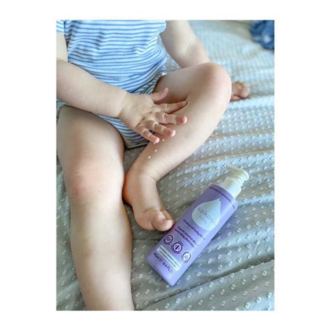 Kūdikis su švelnia oda, apšlakstytas kokosų aliejumi.