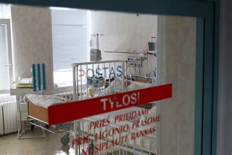 Gydytojas stebi naujagimį ligoninėje