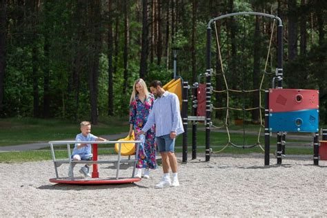 Vaizdas su vaikais, žaidžiančiais lauke prie darželio