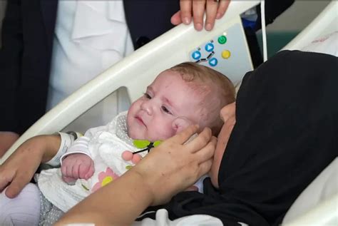 Motina su kūdikiu apžiūri sauskelnių pakuotę prekybos centre Lenkijoje