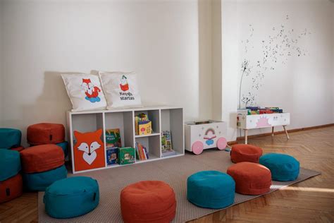 jauki skaitymo erdvė darželio grupėje su vaikams pasiekiamomis knygų lentynomis