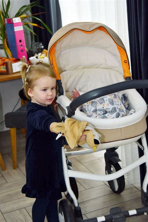 kūdikis besilaikantis už maniežo krašto