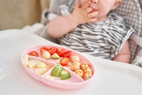 Laimingas kūdikis valgo daržovių košę