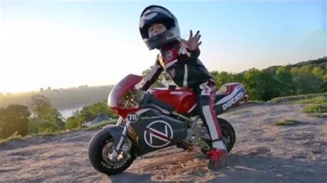 vaikas važiuojantis vaikišku motociklu