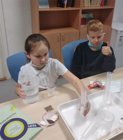 vaikai atliekantys STEAM eksperimentą laboratorijoje