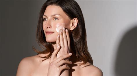 Moteris besitepanti veido kremą