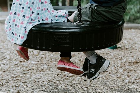 Motina su dviem mažais vaikais žaidžia parke