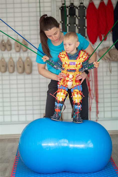 Kūdikis žaidžia ant Fisher-Price kilimėlio gulėdamas ant nugaros su žaislų lanku