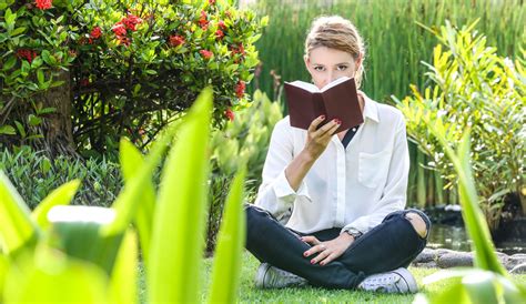 Asmuo ramiai skaito knygą parke, atrodydamas atsipalaidavęs